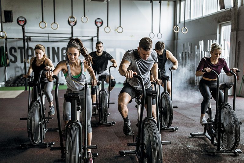 people having sports training on exercise bikes