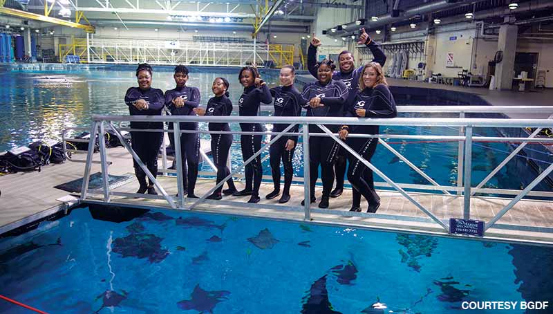 minority students preparing to dive at aquarium