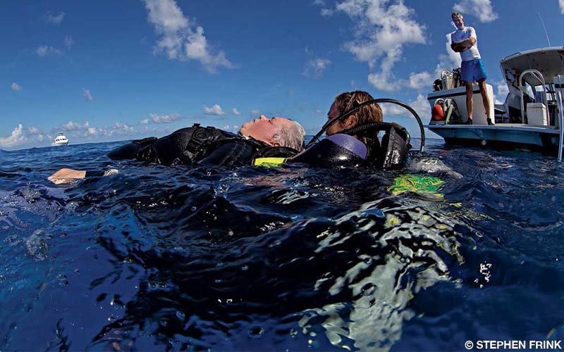 Woman diver tows an unconscious diver