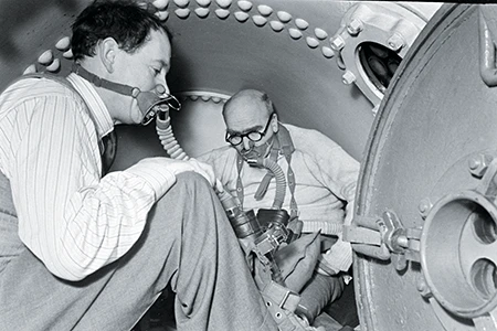 Edwin Martin Case and J.B.S. Haldane demonstrate the experimental setup inside a hyperbaric chamber