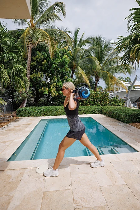 Woman presses up in a split stance position until her legs are straight.