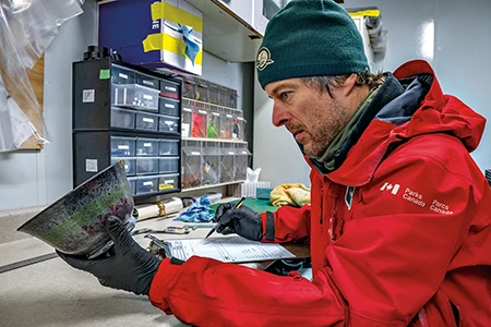 Charles Dagneau examines a ceramic bowl.