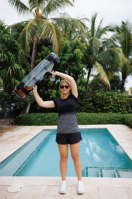 Woman during Halo, swinging the bag to the right, bringing it behind and above her head.