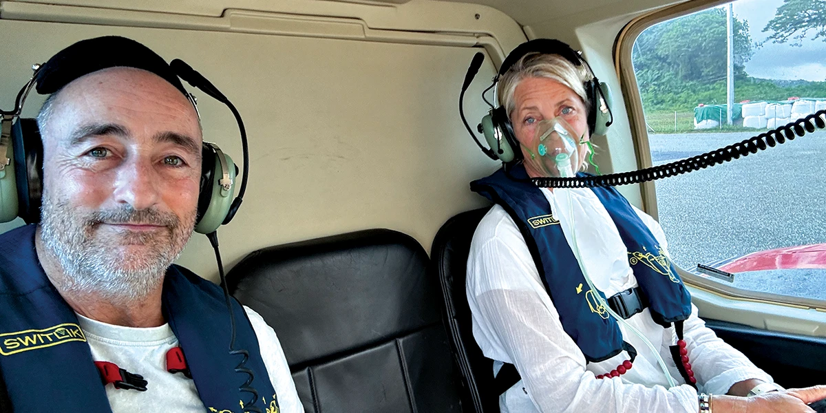 Allen breathes supplemental oxygen during a helicopter transfer to Honiara Hospital with Marco by her side.