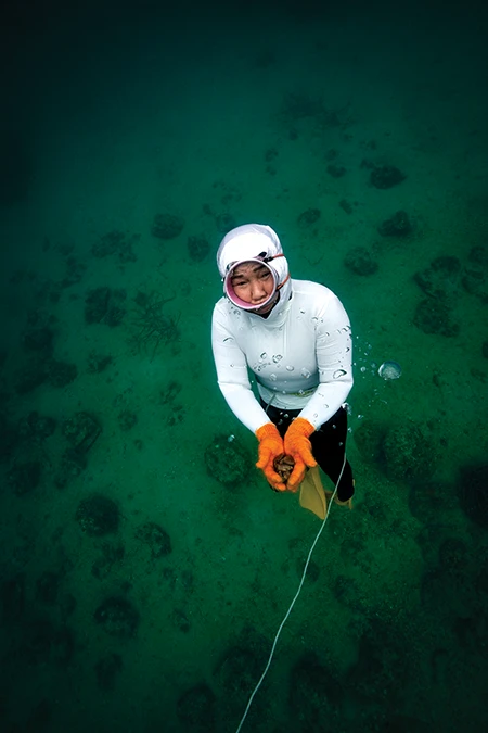 Hayashi rises with her catch on a single breath.